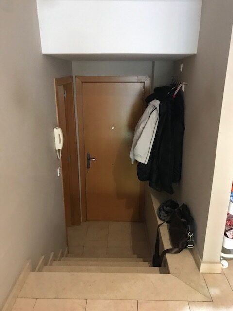 Escalera con puerta y abrigos colgados